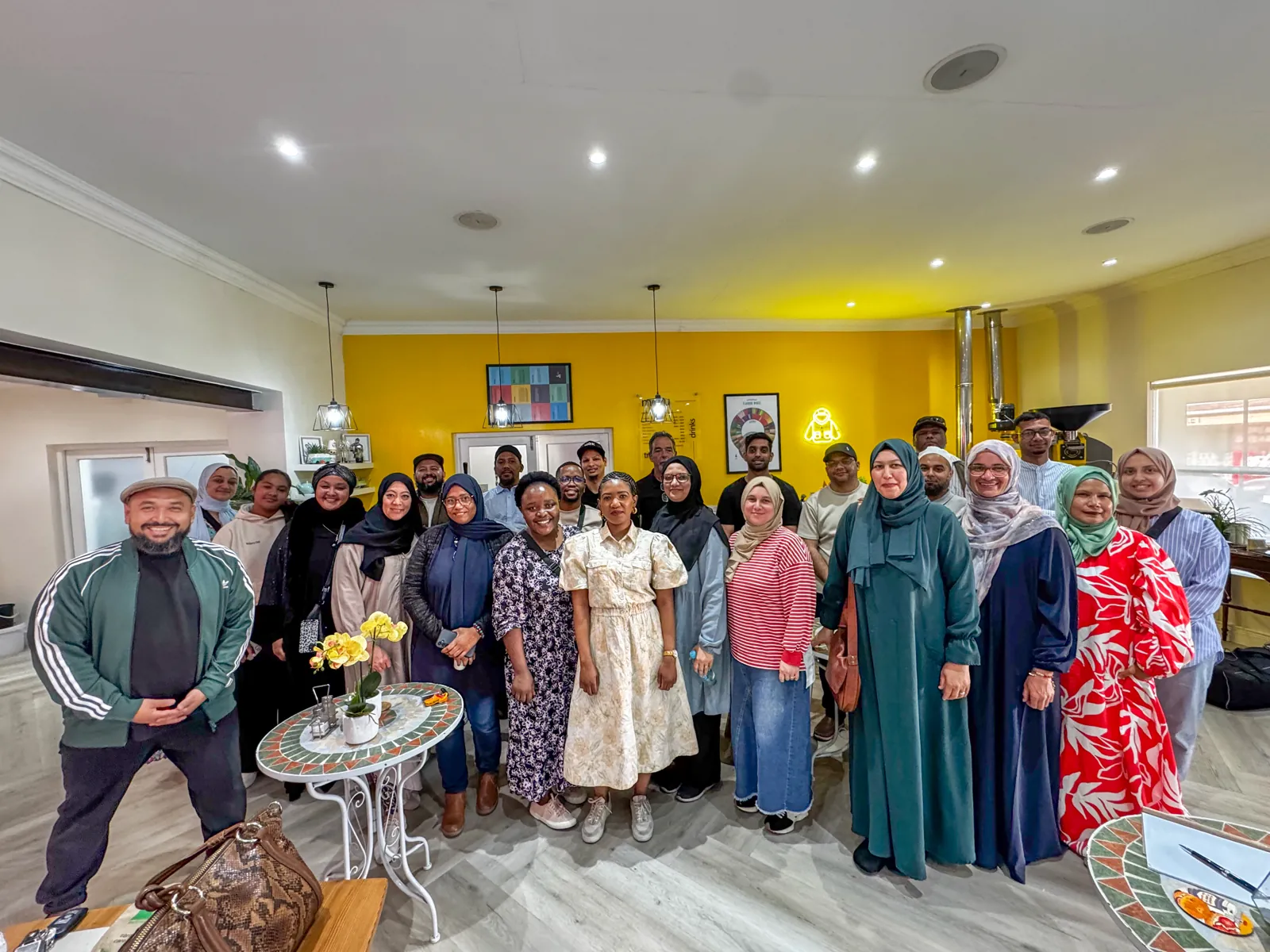 A full room of Harpford Academy workshop attendees smiling for a group photo with Khaalid